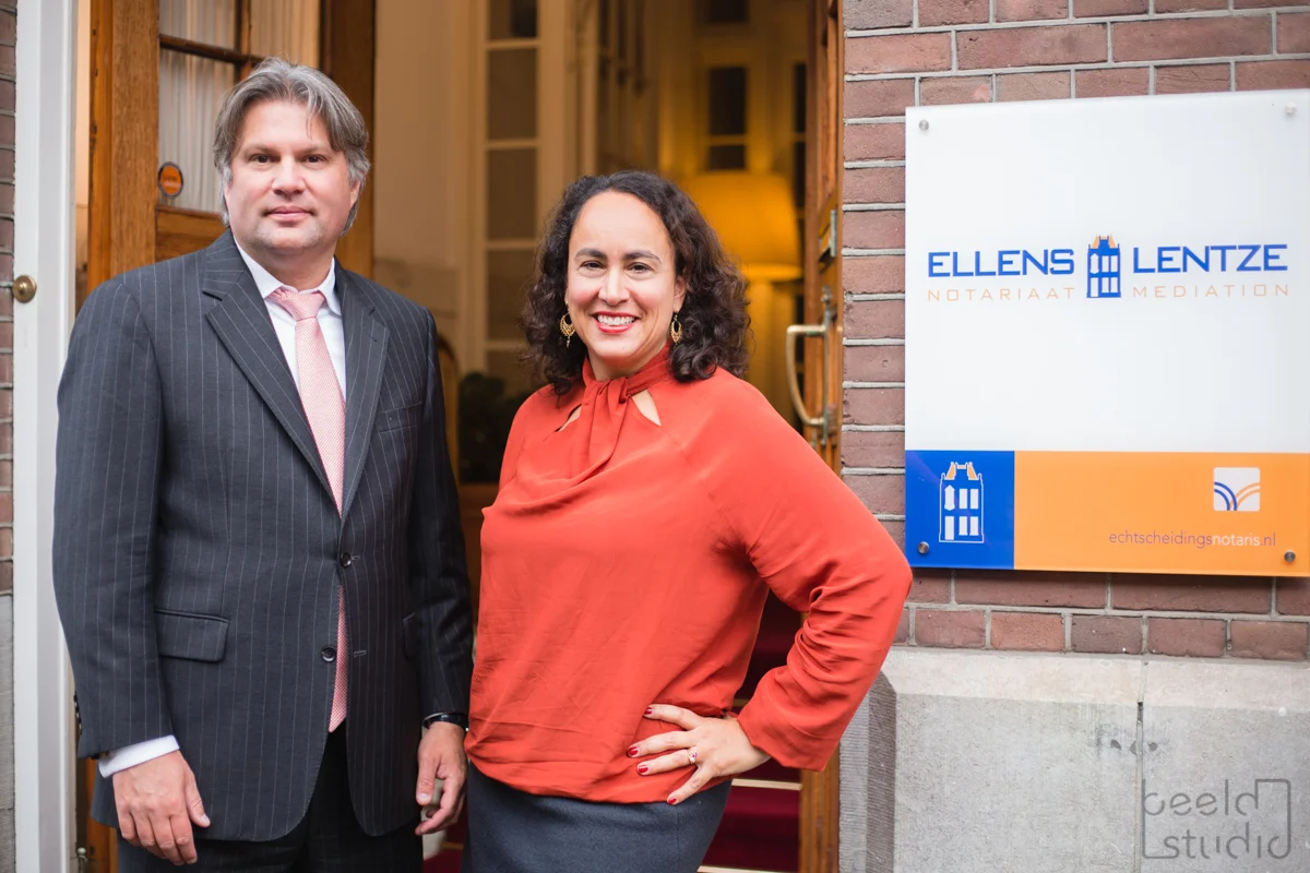 Een man in pak en een vrouw poseren naast het logobord van Ellens & Lentze